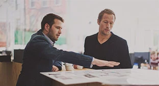 Zwei Männer unterhalten sich und trinken Jacobs Professional Kaffee